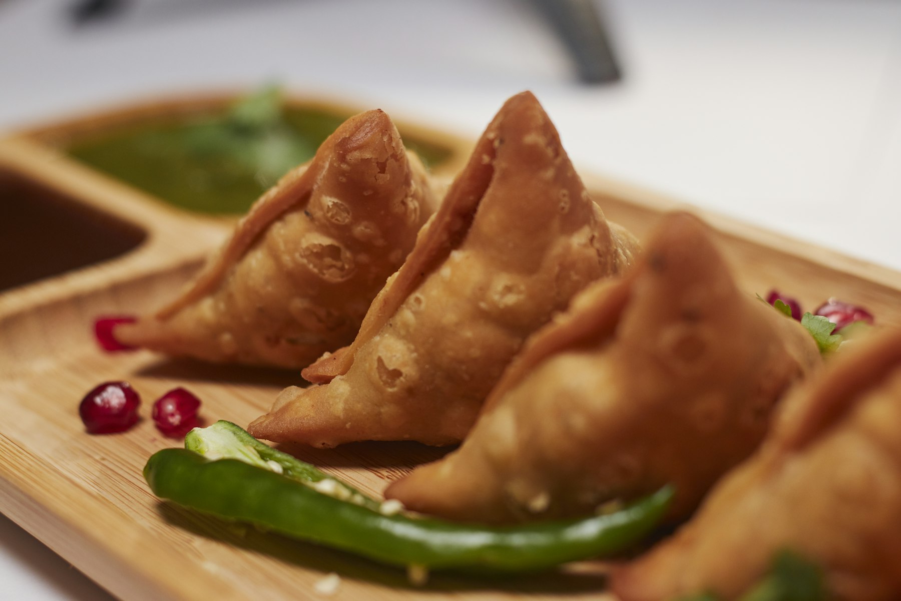Freshly fried samosas served with mint chutney