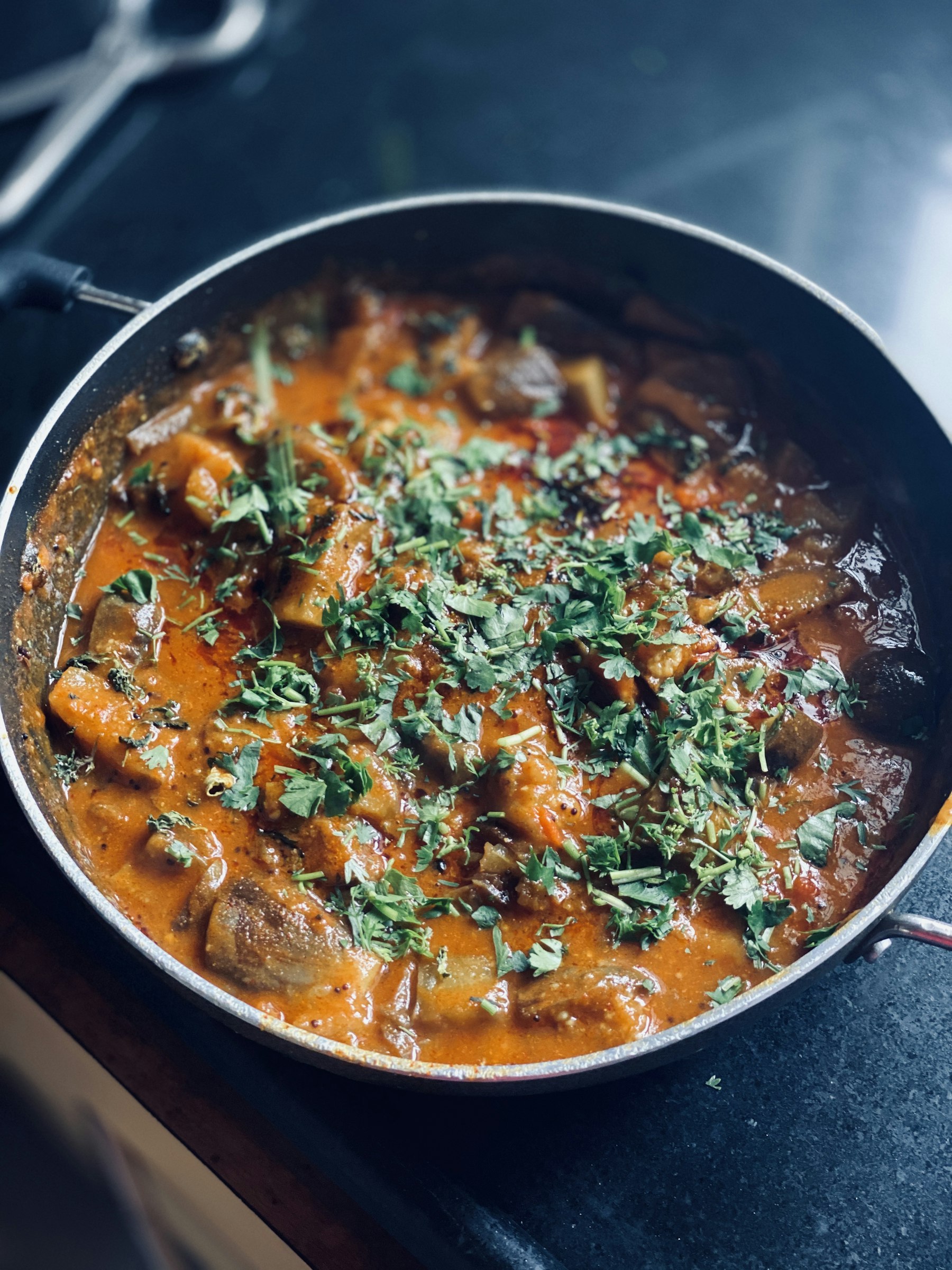 A large karahi of slow-cooked curry finished with coriander