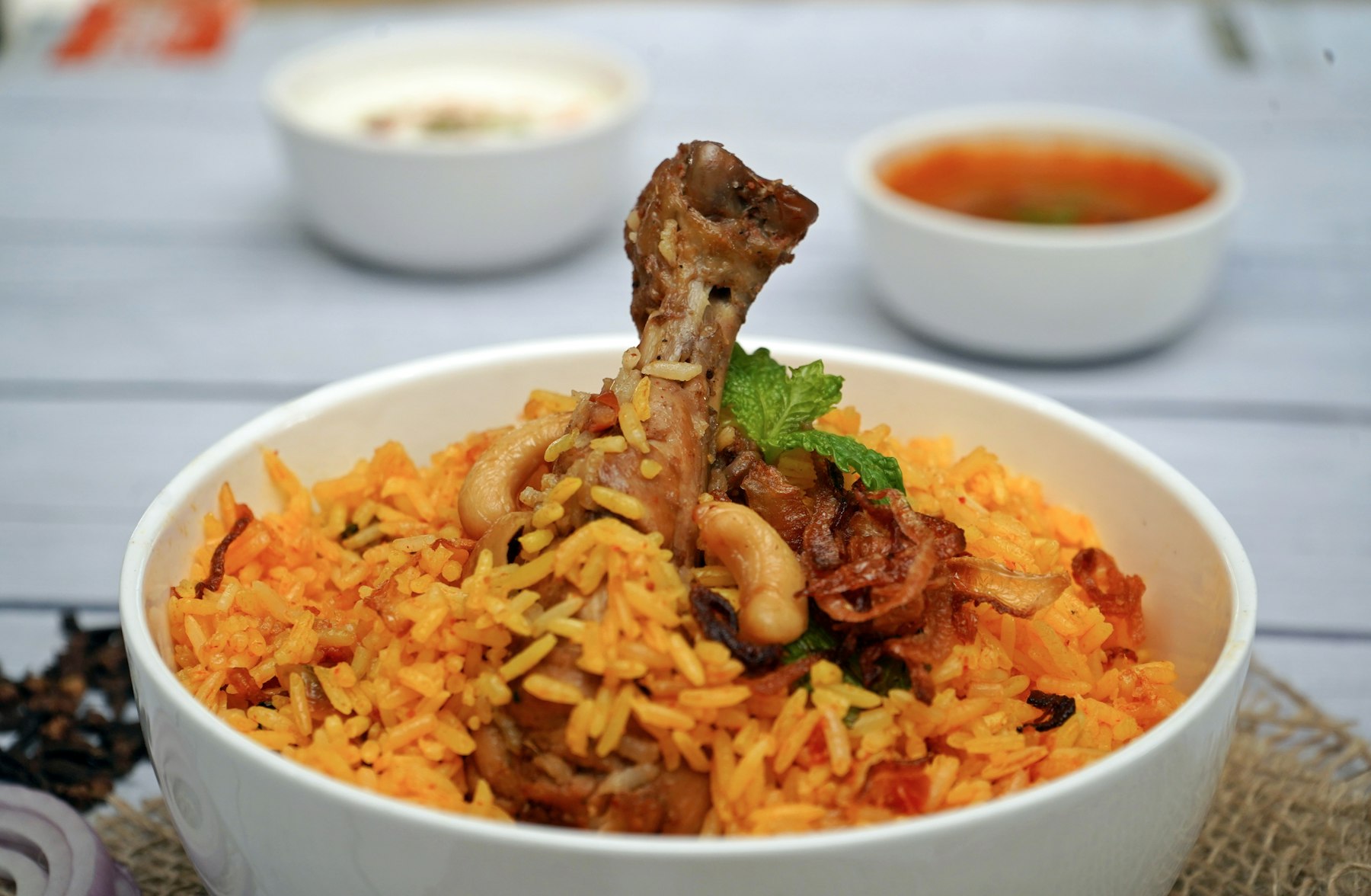 A bowl of Taj biryani with saffron rice, cashew and mint