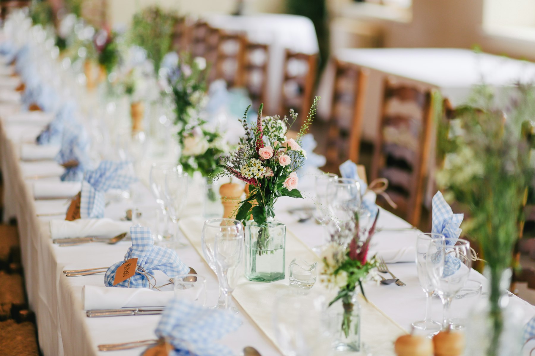 A long banquet table dressed for a wedding reception